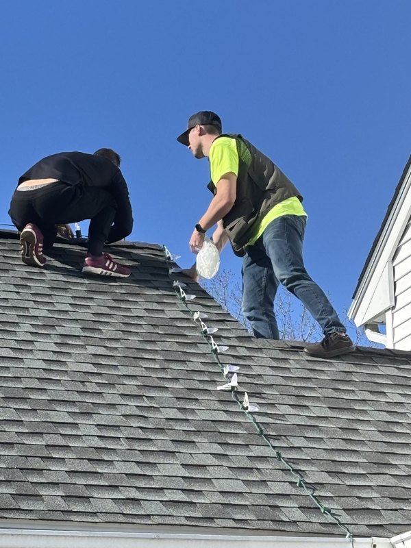 Justin and Mikey on a roof hanging Christmas lights